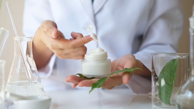 Farmacista con in mano una crema aperta 